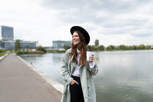 Europeo sorridente giovane donna d'affari cammina lungo il lungomare durante il giorno e si rilassa. - Foto, immagini