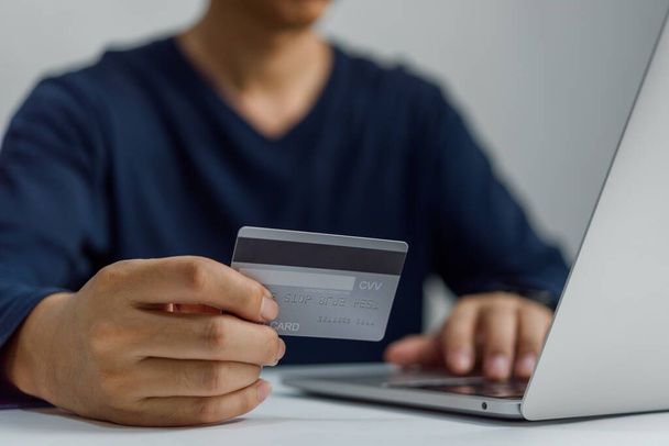 Muž drží kreditní kartu a pomocí notebooku. Podnikatel nebo podnikatel práce, e-commerce, internetové bankovnictví Online nakupování. - Fotografie, Obrázek