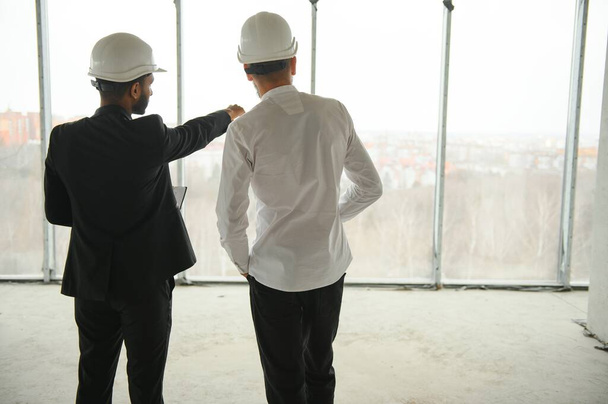 Multiethnic business team. Construction concept. Indian and Arab engineers inspect the construction - Foto, afbeelding