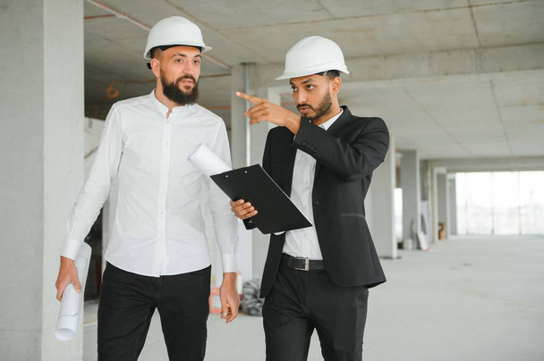 Multiethnic business team. Construction concept. Indian and Arab engineers inspect the construction - Fotoğraf, Görsel
