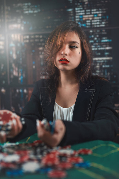 girl as a poker player with a lot of colored chips at a round green table. casino poker concept woman. big win - Photo, image