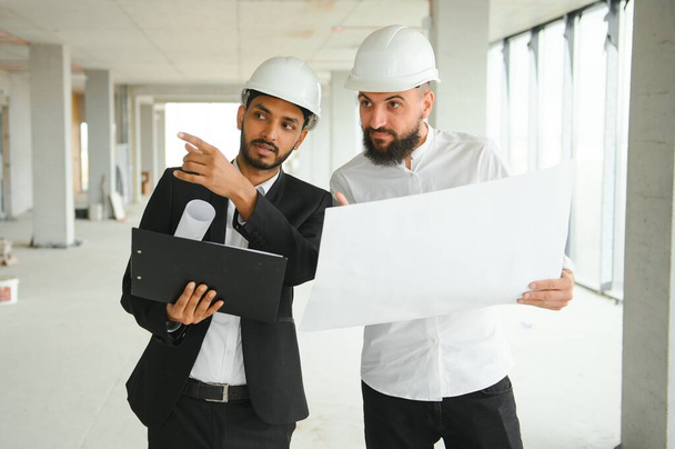 Multiethnic business team. Construction concept. Indian and Arab engineers inspect the construction - Foto, imagen