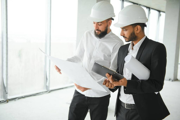 Multiethnic business team. Construction concept. Indian and Arab engineers inspect the construction - Foto, Imagem