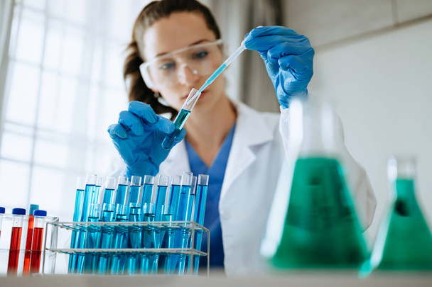 Female biotechnologist testing new chemical substances in a laboratory. - Фото, зображення