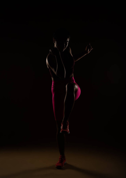 Una foto frontale di una donna sportiva che allunga la gamba sinistra - Foto, immagini