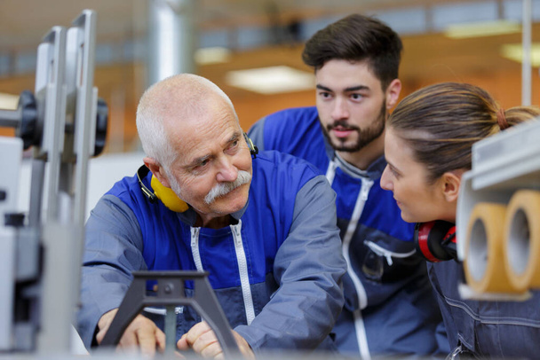 portrait of engineers and apprentices in busy factory - Foto, immagini