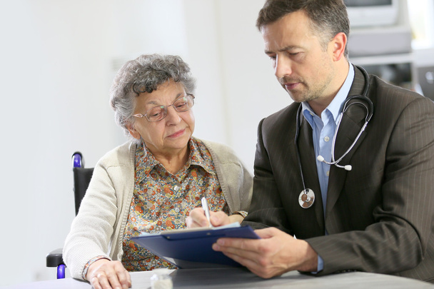 Doctor visiting elderly woman - Foto, imagen