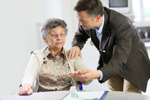 Doctor reassuring elderly woman - Foto, Bild