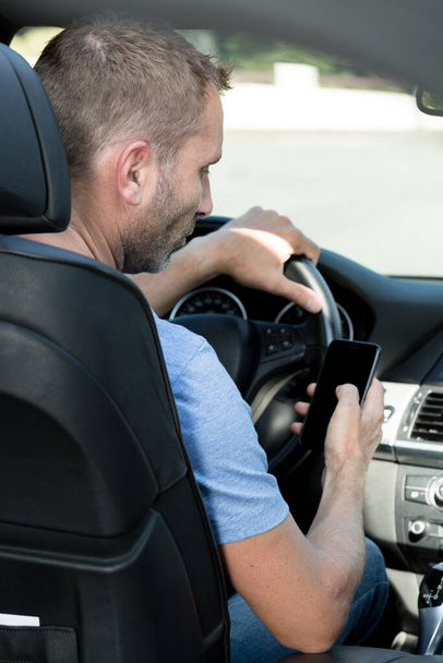 man sending a text while driving - Foto, imagen