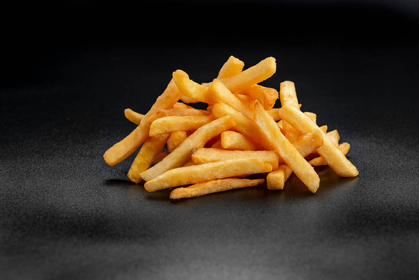 Pile of french fries over black background. Photo for the menu - Fotó, kép