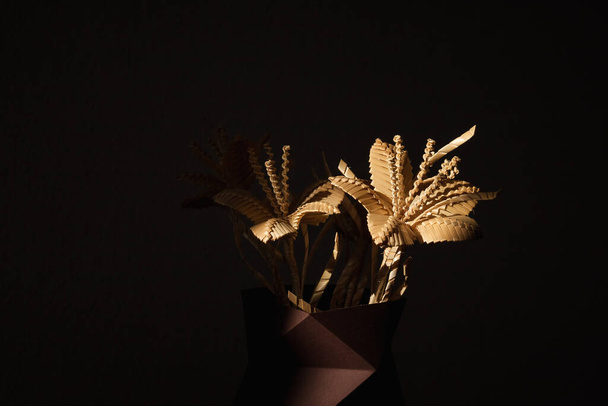 Flower made of straw on a dark background. The flower is illuminated by the sun. Small depth of field. Place for text - Fotografie, Obrázek