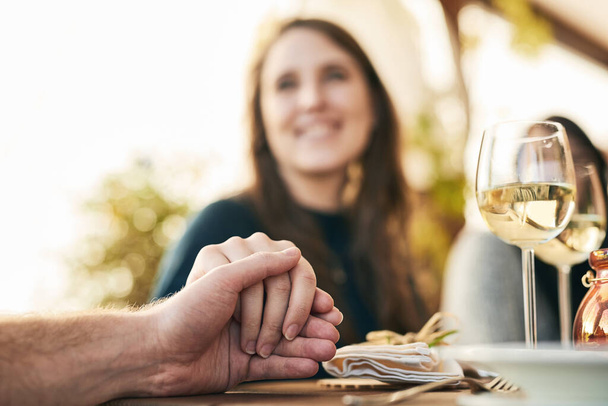Couple, dinner and holding hands to celebrate love, support and marriage together outdoor. Romance date, woman and lunch with man for quality time, happy celebration or bonding at restaurant outside. - Photo, Image