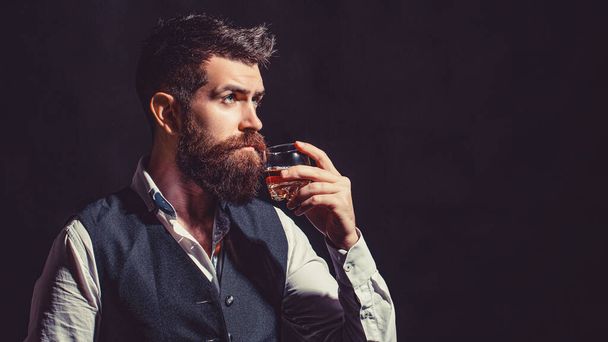 Sommelier tastes expensive drink. Bearded businessman in elegant suit with glass of whiskey. - Photo, Image