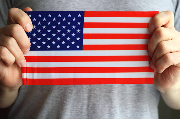 US flag in human hands, close-up photo. - 写真・画像