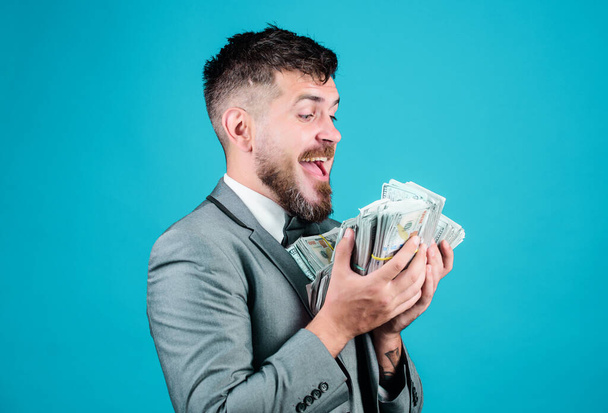 Businessman got cash money. Gain real money. Richness and wellbeing concept. Cash transaction business. Easy cash loan. Man formal suit hold many dollar banknotes blue background. Take my money. - Фото, изображение