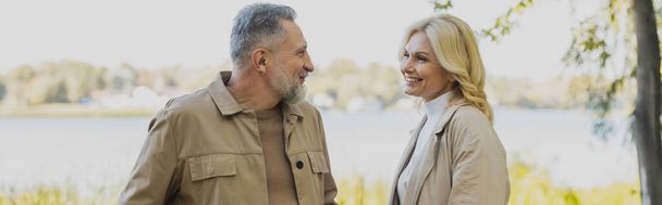 Positive mature couple talking while spending time in park, banner  - Photo, Image
