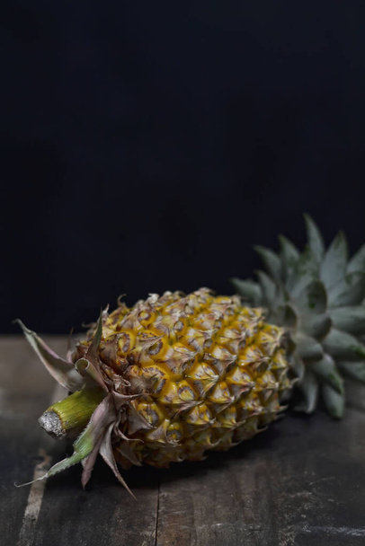 Fresh Pineapple on a board on a dark background - Фото, изображение