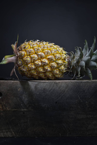 Fresh Pineapple on a board on a dark background - Φωτογραφία, εικόνα