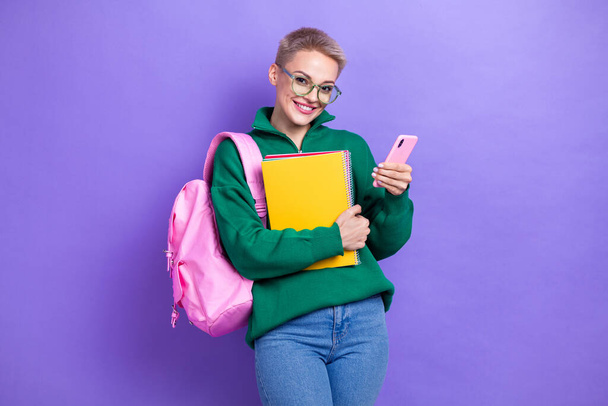 Portrait of charming positive person hold use telephone notebook isolated on purple color background. - Foto, afbeelding