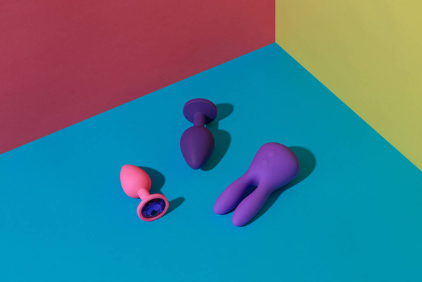 Buttplugs and dildos for anal sex on colored background. Sex shop concept. High quality photo - Fotografie, Obrázek