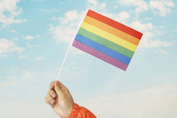 Гей гордость радуга флага развевается подсветкой на солнце против голубого неба - Фото, изображение