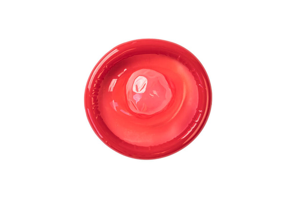 白い背景に隔離された赤いゴムのコンドーム - 写真・画像