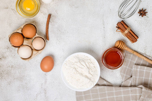 Baking homemade cookies on gray kitchen worktop with ingredients -flour, eggs,  sugar and  cinnamon. culinary background, copy space, overhead view - Photo, image