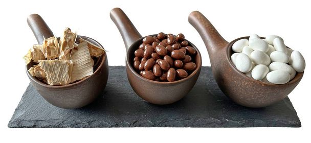 Braune Keramik für Süßigkeiten mit Nüssen in Vollmilchschokolade und weißer Schokolade. Kraft Steingut für schöne Tischdekorationen in Restaurants. Ansicht von oben. Isoliert - Foto, Bild