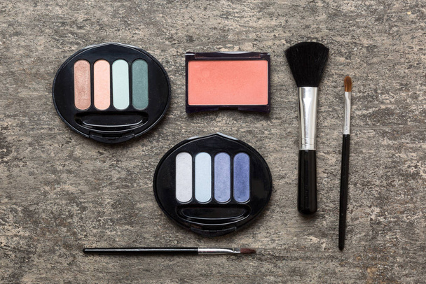 Professional makeup tools. Top view. Flat lay. Beauty, decorative cosmetics. Makeup brushes set and color eyeshadow palette on table background. Minimalistic style. - Photo, Image