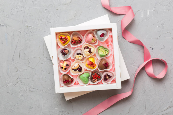 Holiday composition: sweet candy, with gift boxes with bow and chocolate hearts, photo template, background. Top View with copy space on colored background. - Foto, afbeelding