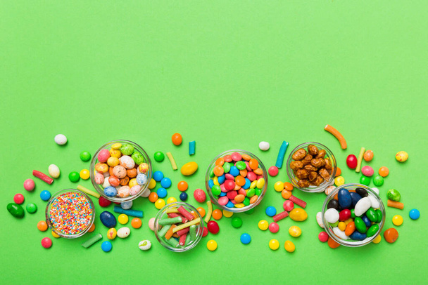 different colored round candy in bowl and jars. Top view of large variety sweets and candies with copy space. - Photo, Image