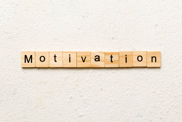 Motivációs szó fablokkra írva. Motivációs szöveg cement asztalon a desing, koncepció. - Fotó, kép