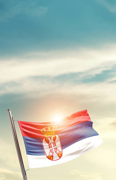 Сербія махає прапором у прекрасному небі з сонцем. - Фото, зображення