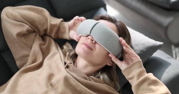 Le visage d'une femme avec un masque virtuel pour dormir, gros plan, vue surélevée. Dispositif domestique pour la relaxation - Séquence, vidéo