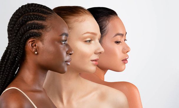 Beautiful multiethnic young women posing naked on white studio background, three half-naked millennial ladies with long hair looking at copy space, banner, diversity in beauty concept - Fotoğraf, Görsel