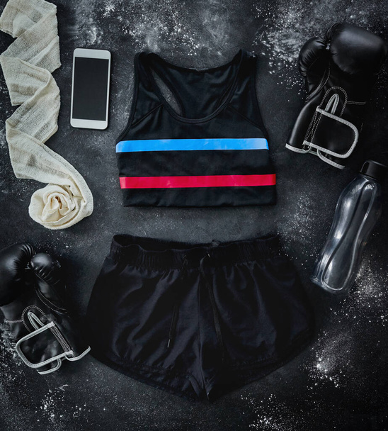 I have the perfect outfit. High angle shot of boxing essentials placed on top of a dark background inside of a studio - Valokuva, kuva