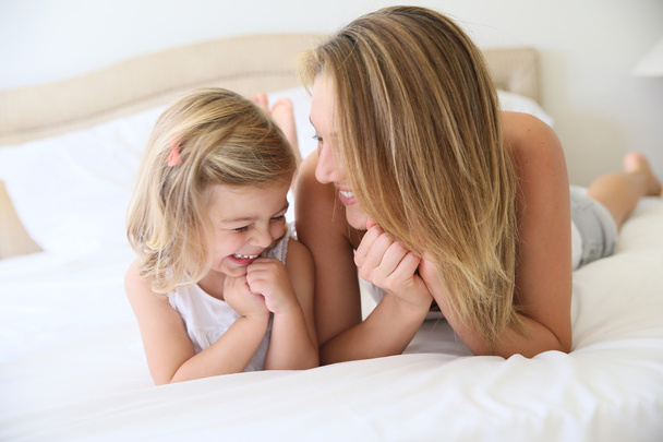 Girl with mommy laying on bed - Foto, immagini