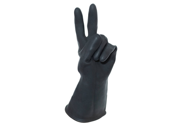Un gant isolé en caoutchouc noir tenant l'index et les majeur en victoire sur fond blanc. Une main faisant le geste numéro deux - Photo, image