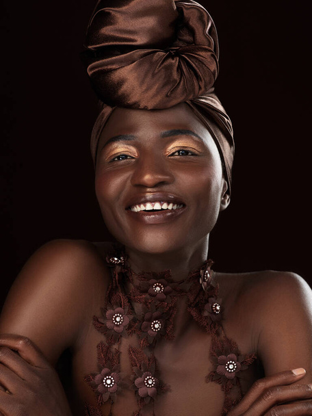 Fall in love with the fabulous queen you are. Studio shot of an attractive young woman posing in traditional African attire against a black background - Foto, afbeelding