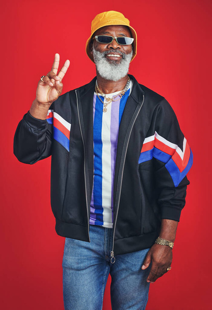 This is what you call swag. Studio shot of a senior man wearing retro attire while posing against a red background - Fotografie, Obrázek