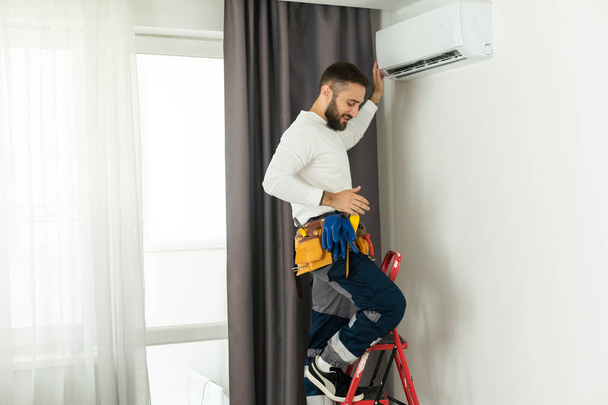 Technician repairing air conditioner on the wall. - Photo, Image
