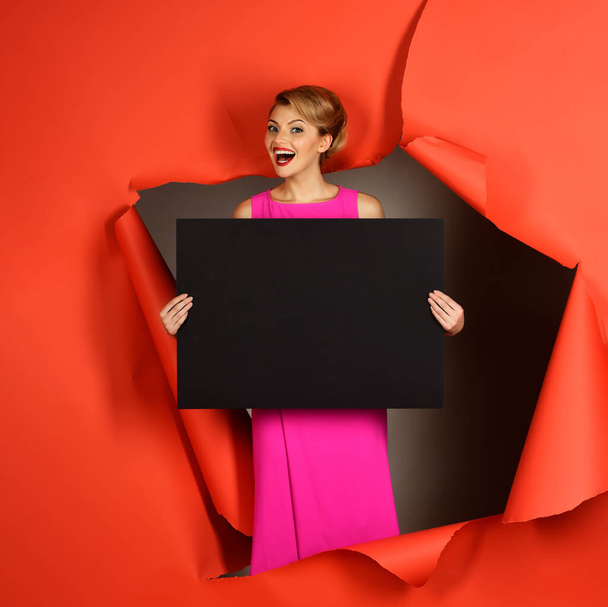 Happy woman in pink dress with blank board for your text. Sensual blonde model with empty banner. Blank banner or empty advertising board. Summer sale. Fashion products. Copy space for advertising - Fotografie, Obrázek