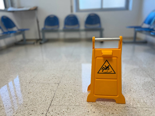 Rutschiges Schild auf nassem Fußboden in Bürogebäude - Foto, Bild