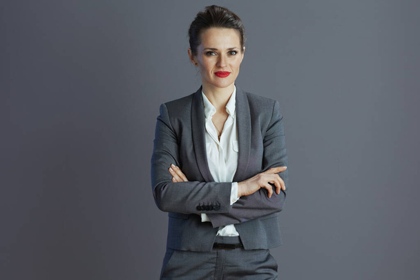 modern woman worker in grey suit against gray background. - Photo, image