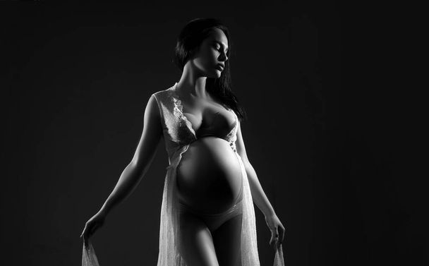 Belly of a pregnant woman. Pregnancy. Woman studio intimate portrait. Happy pregnant woman. Happy pregnant. Isolated on black studio background - Fotoğraf, Görsel