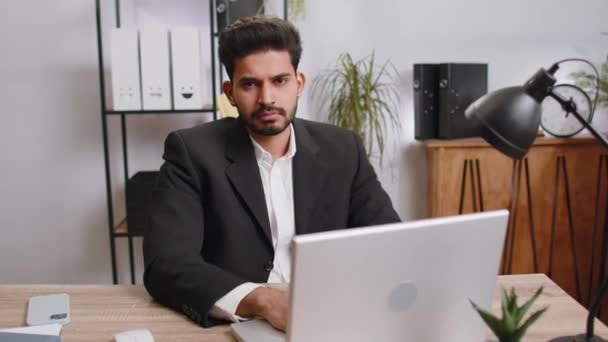 I dont know what to say. Confused business man working on laptop at office workplace. Freelancer feeling embarrassed about ambiguous question, having doubts, no answer idea, being clueless, uncertain - Materiał filmowy, wideo