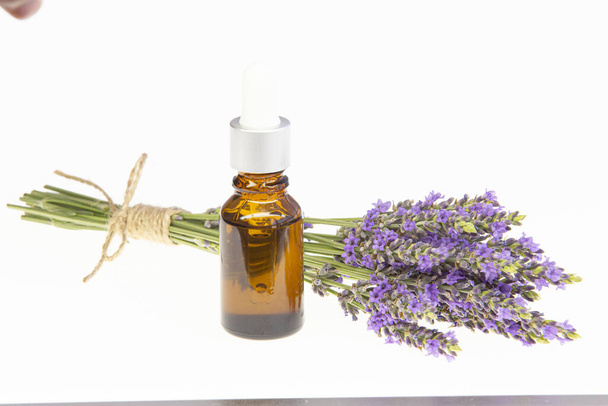 Amber essential lavender oil bottle. Pipette with drop and bottle on an isolated background - Photo, Image