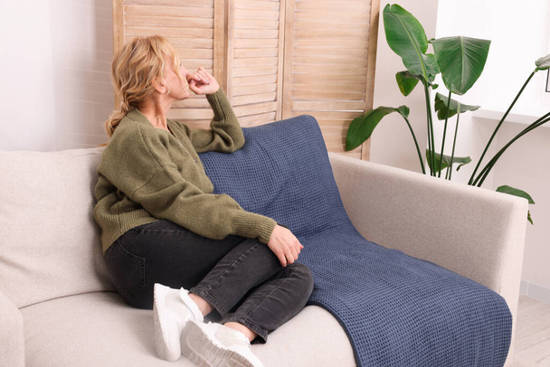 Woman sulking on sofa in living room. Loneliness concept - Φωτογραφία, εικόνα