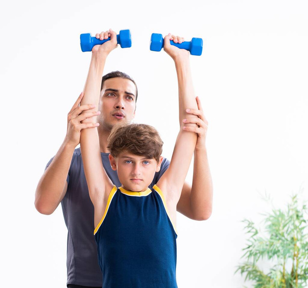 Le jeune père et son fils font des exercices
 - Photo, image