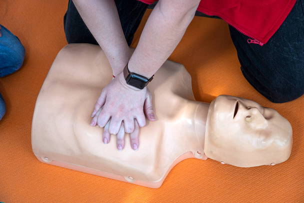 女性はトレーニングのためにマネキンでCPRを行う。直接心臓マッサージ。救急医療用ダミーの訓練だ。心停止中の心臓マッサージ - 写真・画像